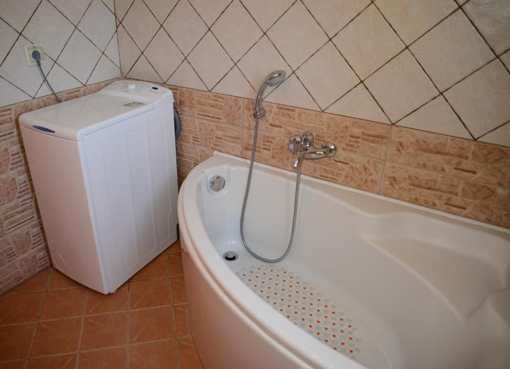 Bathtub and washing machine at Andri House