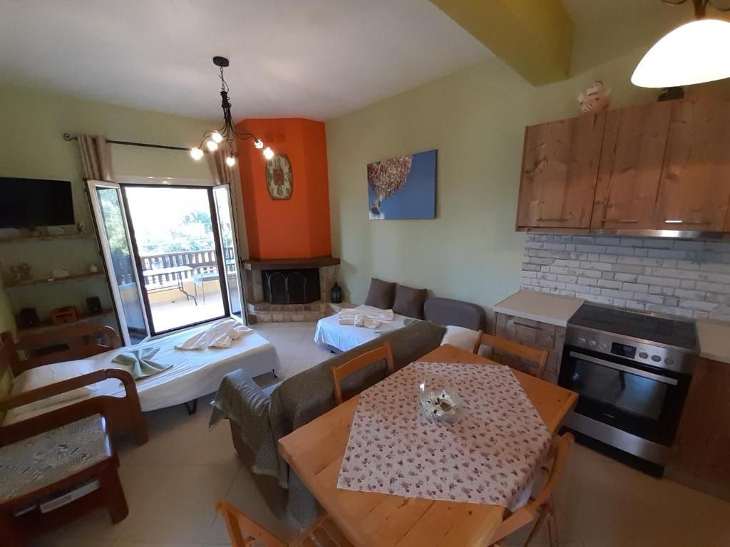 Open-plan kitchen and living room with fireplace, dining table and sofa bed