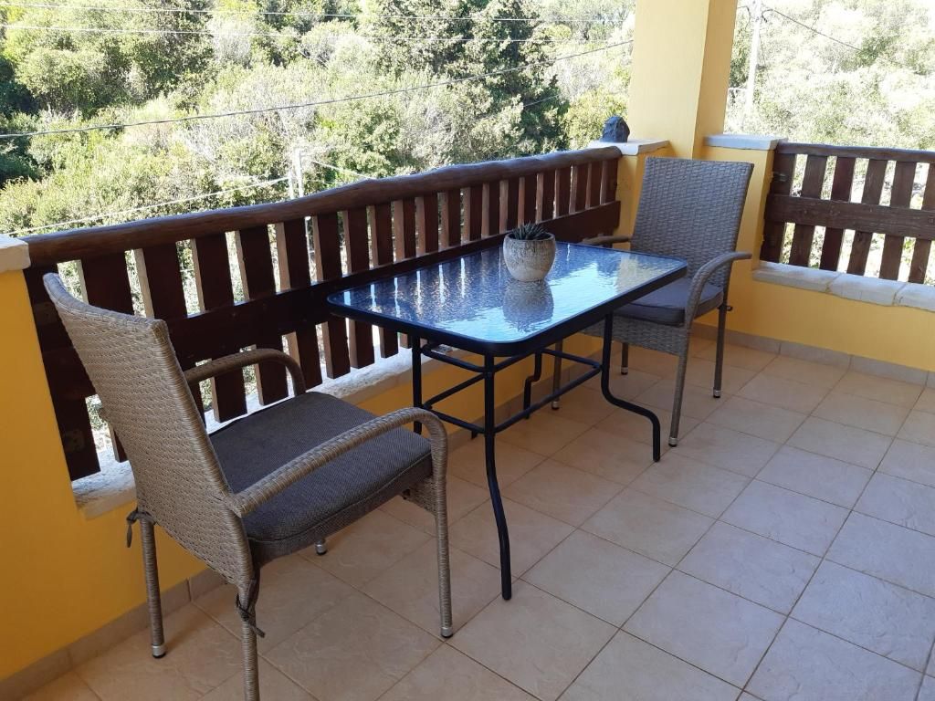 Terrace with table and chairs looking out over the olive trees towards the hills